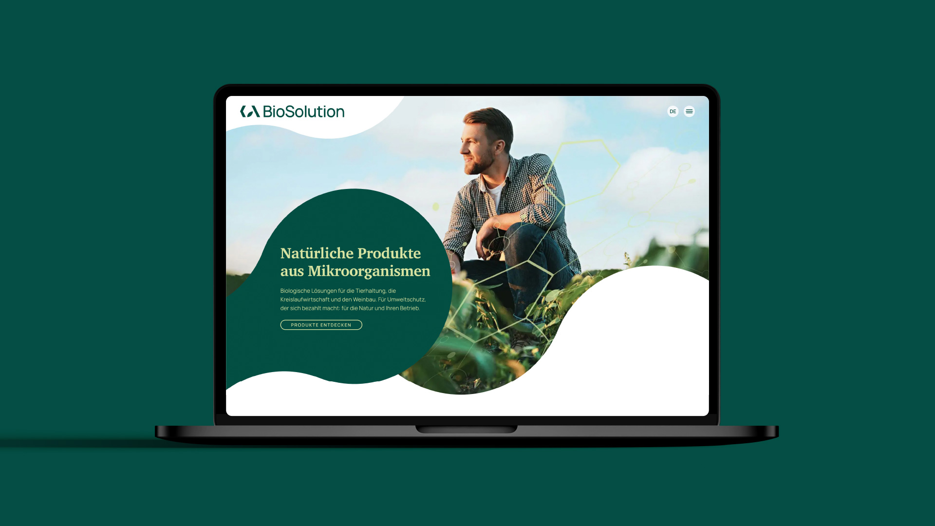 Ein Laptop-Bildschirm auf gründem Hintergrund, der die Startseite der KA-BioSolution zeigt.